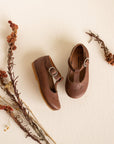Adelisa & Co t-bar Mary Janes with delicate floral detailing in dark brown leather. These leather Mary Jane shoes for girls are handmade and feature a buckle closure.