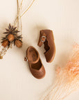 Adelisa & Co handmade leather Mary Janes for girls featuring leaf detailing across the toe and scalloped edging. These Mary Jane leather shoes for girls come in a medium brown leather.