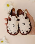 Closed toe, vintage style cream leather sandals for girls with floral detailing.