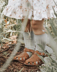 Adelisa & Co medium brown leather sandals for girls with floral detailing.