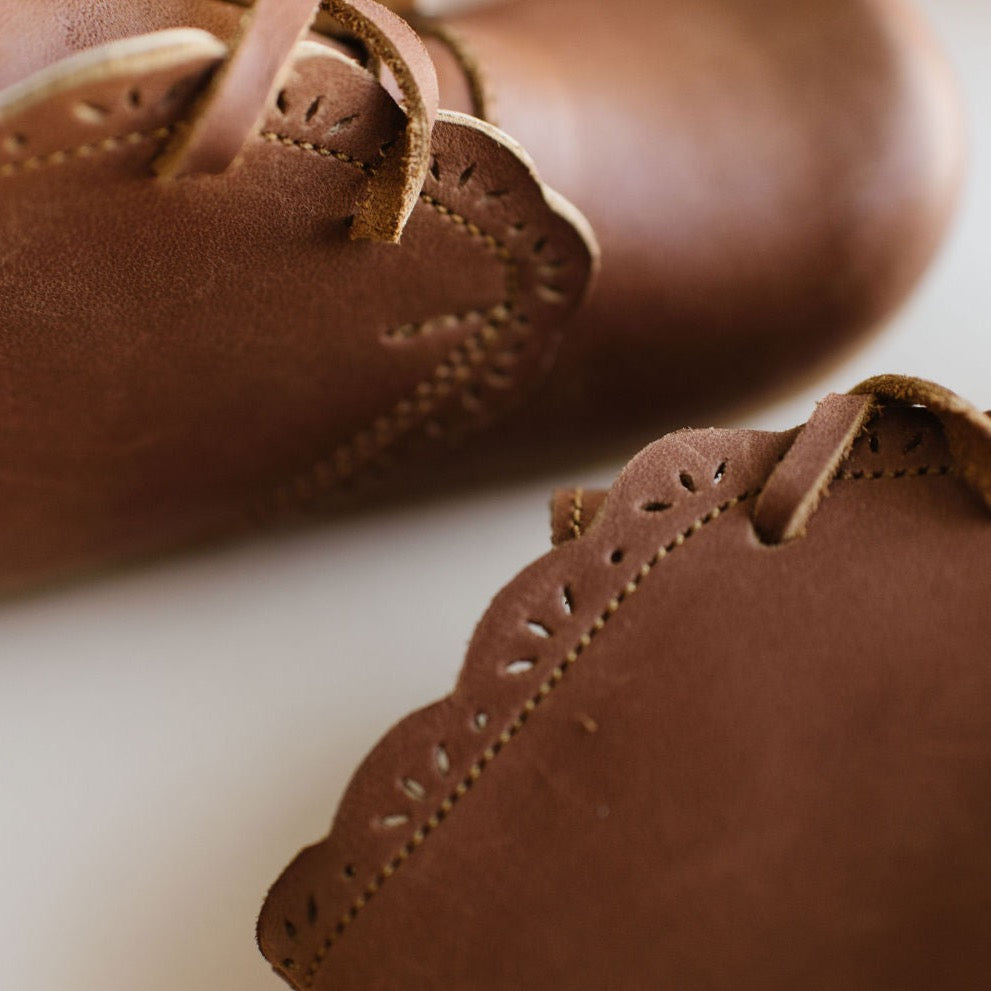 Adelisa & Co handmade leather Primavera boots in a medium brown tone. These leather children's boots feature beautiful scallop edging and subtle floral details.
