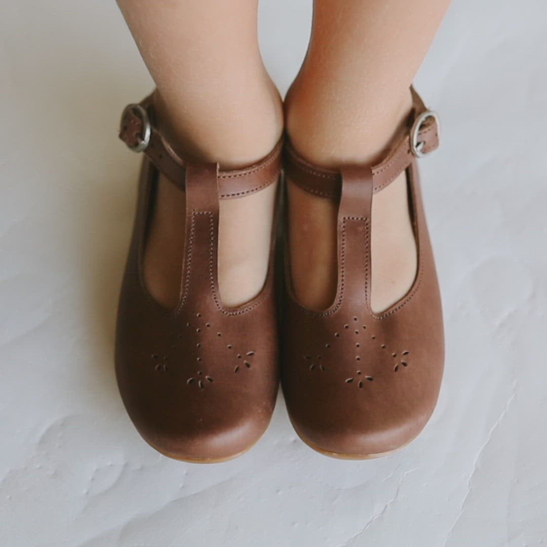 Adelisa & Co t-bar Mary Janes with delicate floral detailing in dark brown leather. These leather Mary Jane shoes for girls are handmade and feature a buckle closure.