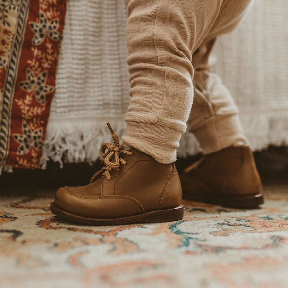 Adelisa &amp; Co. Vintage style leather boots for children. Our Antigua leather boots come in a medium brown leather and feature a simplistic design with a round toe. Unisex style
