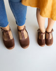 Dark brown leather Mary Jane shoes for women with floral detailing.
