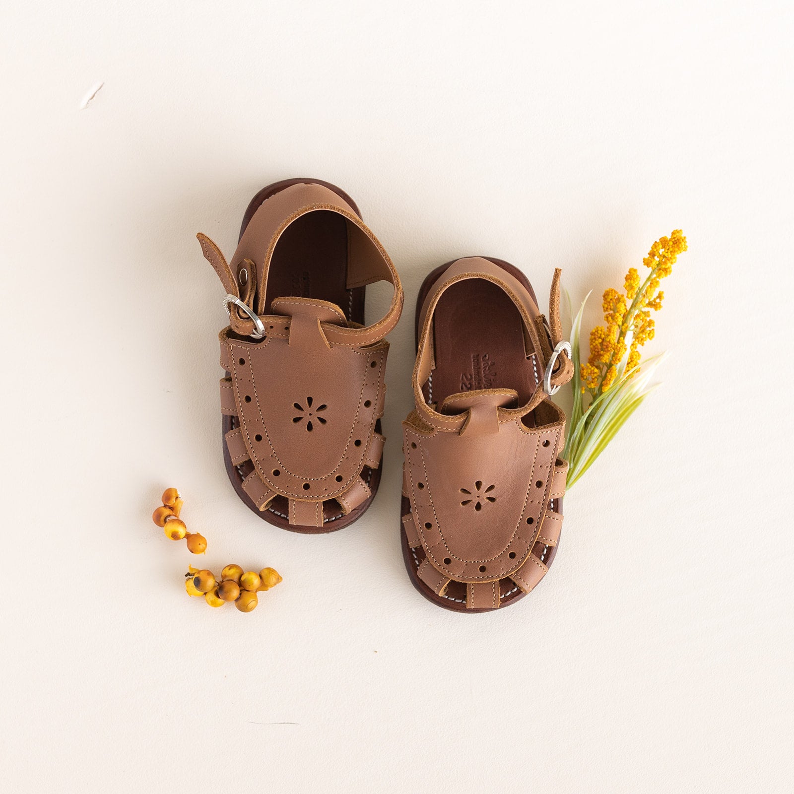 Adelisa & Co medium brown leather sandals for girls with floral detailing.