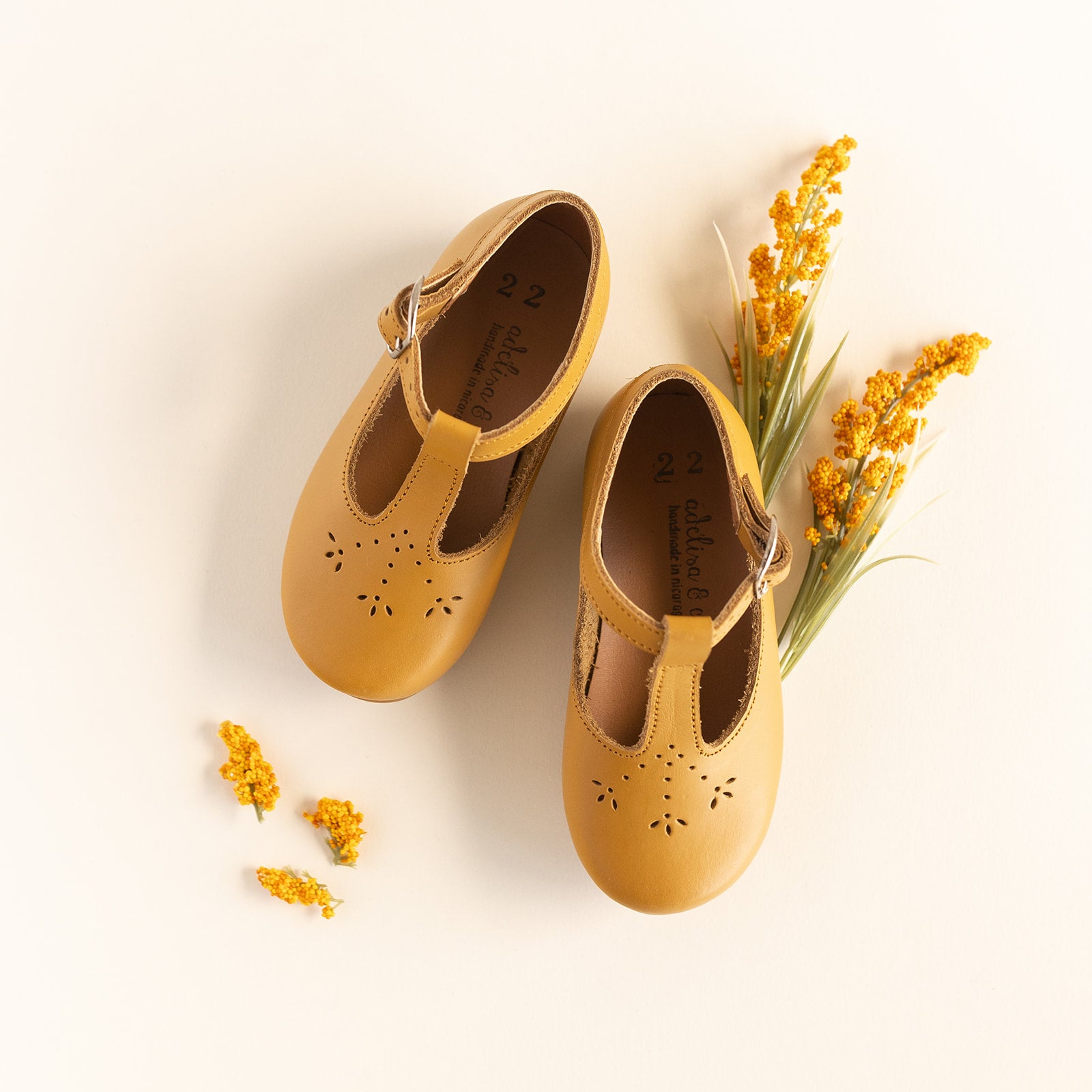 Adelisa & Co mustard yellow leather shoes for girls with floral detailing.