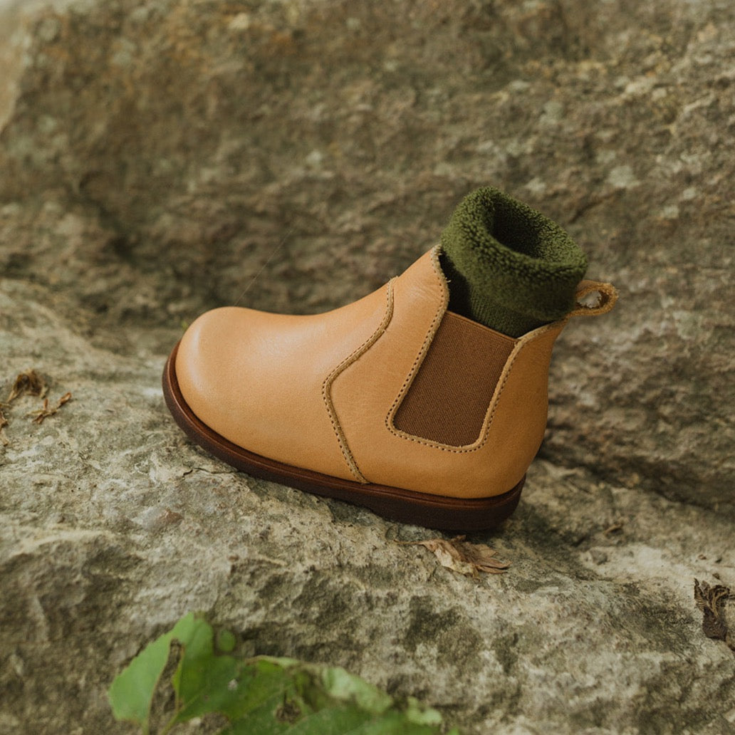 Chelsea style leather boot for children in cognac leather. This slip on boot features an elastic side and flexible soles.