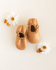 Neutral and simple baby soft sole, pull on loafer with elastic sides. This moccasin style baby shoe is handmade in a cognac colored leather.