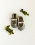 Baby soft sole, slip on Mary Jane with elastic band. This Mary Jane baby shoe comes in a dark, earthy green leather.