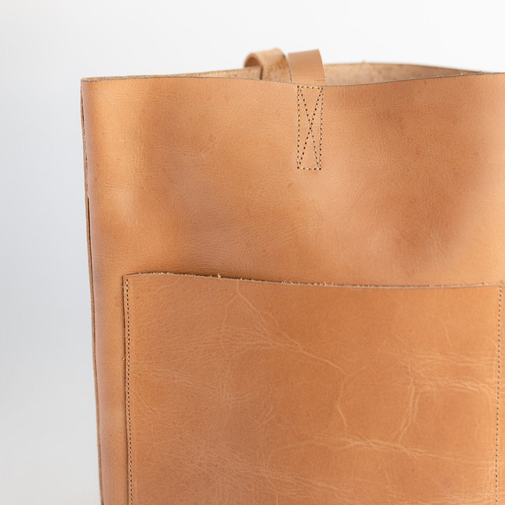 large women&#39;s leather tote bag in a cognac tone. Features to large pockets on the front and no hardware.