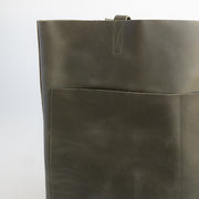 Large Women's leather tote with two front pockets and no hardware in an earthy, dark green leather.