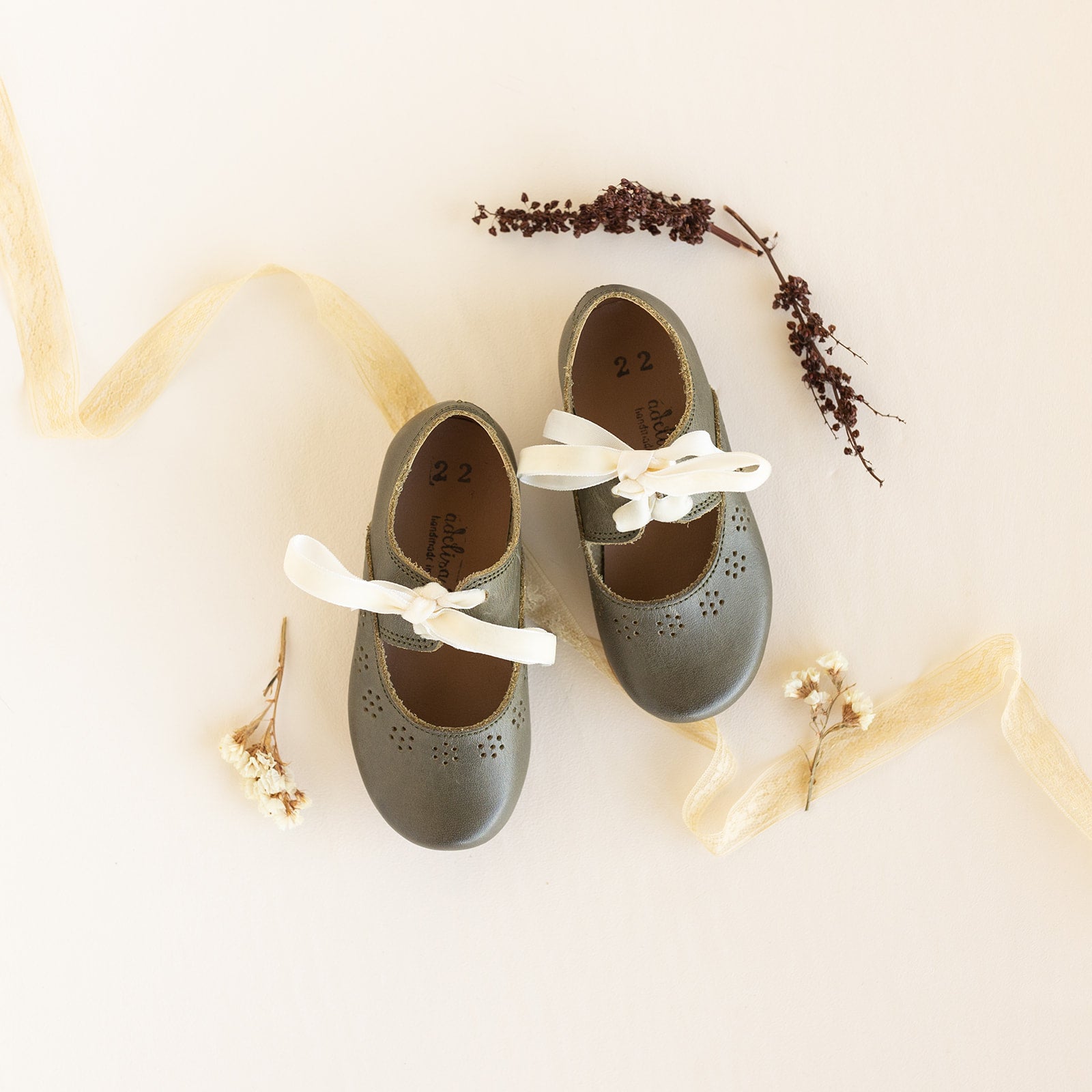 Oxford style Mary Janes with a vintage design. These leather Mary Janes for girls come in a beautiful earthy, dark green leather and have a handcrafted sun design outlining their border.