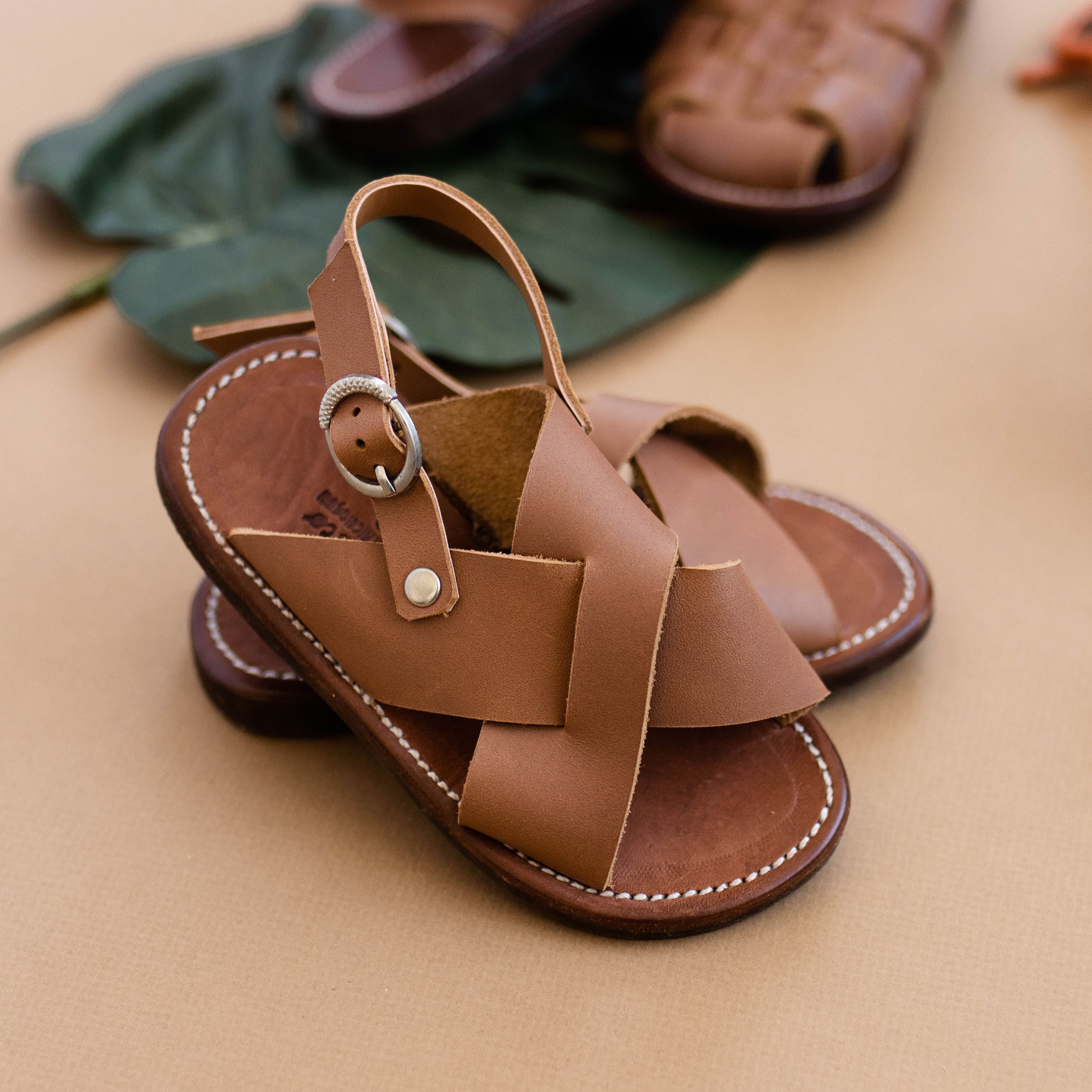 Cross strap, medium brown leather sandals for children. Unisex design.